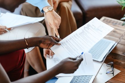 Multiethnic businesswomen checking information in documents